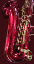 Load image into Gallery viewer, Red and gold saxophone on a wooden surface
